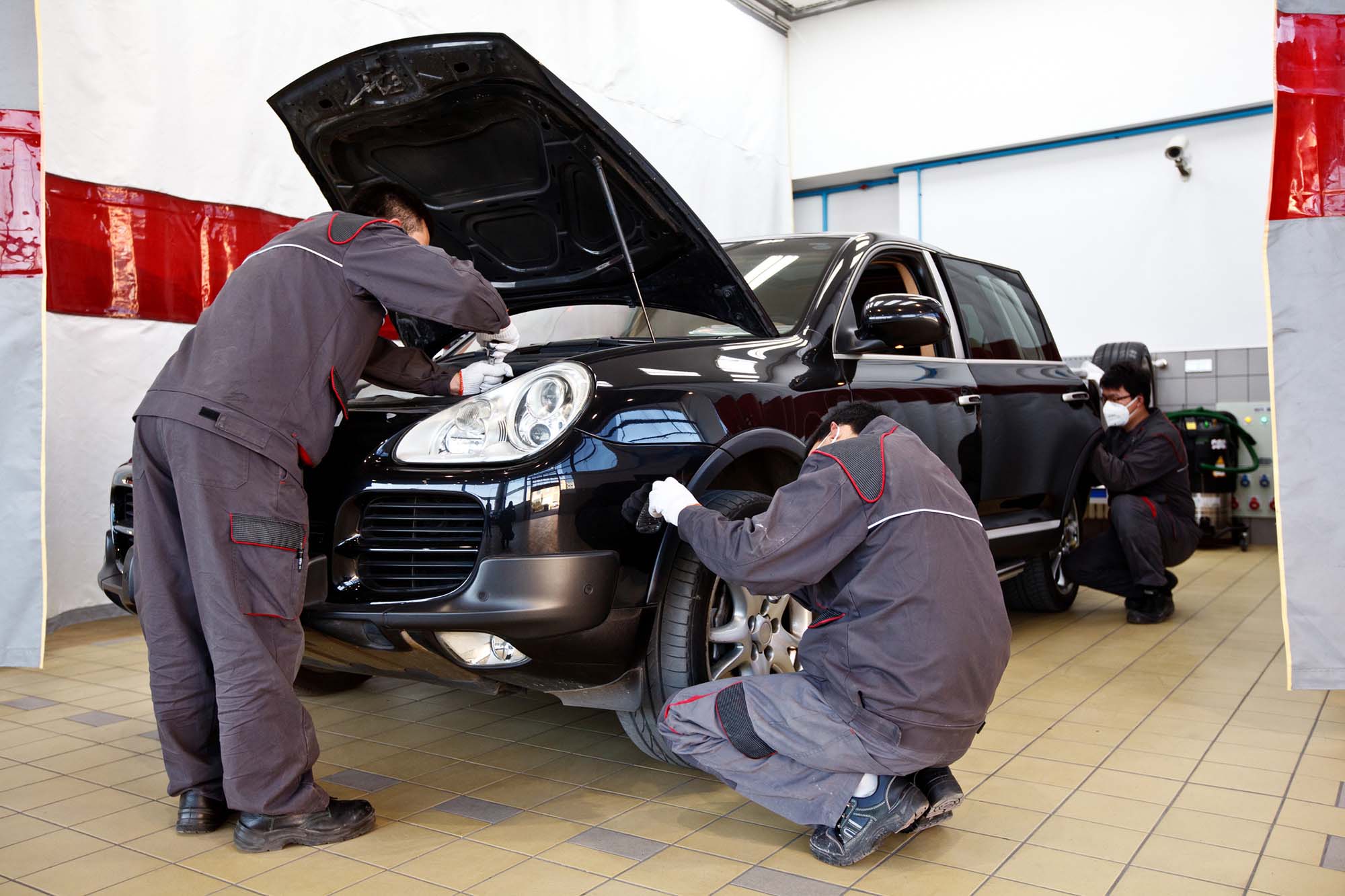 MOTHeroResized 3 men working on Black Porsche jeep